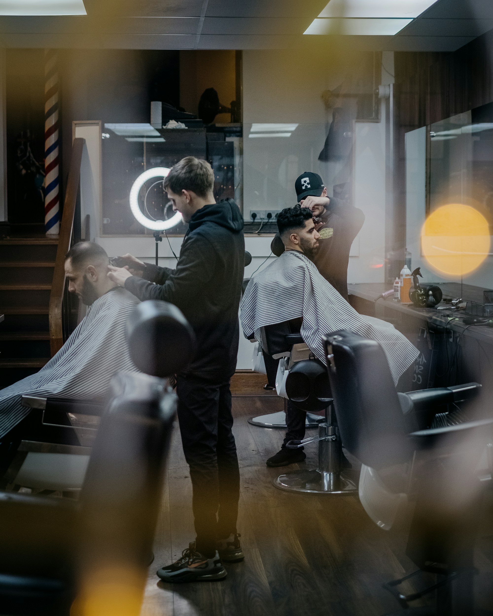 Klien dewasa muda menerima potongan rambut di barbershop premium