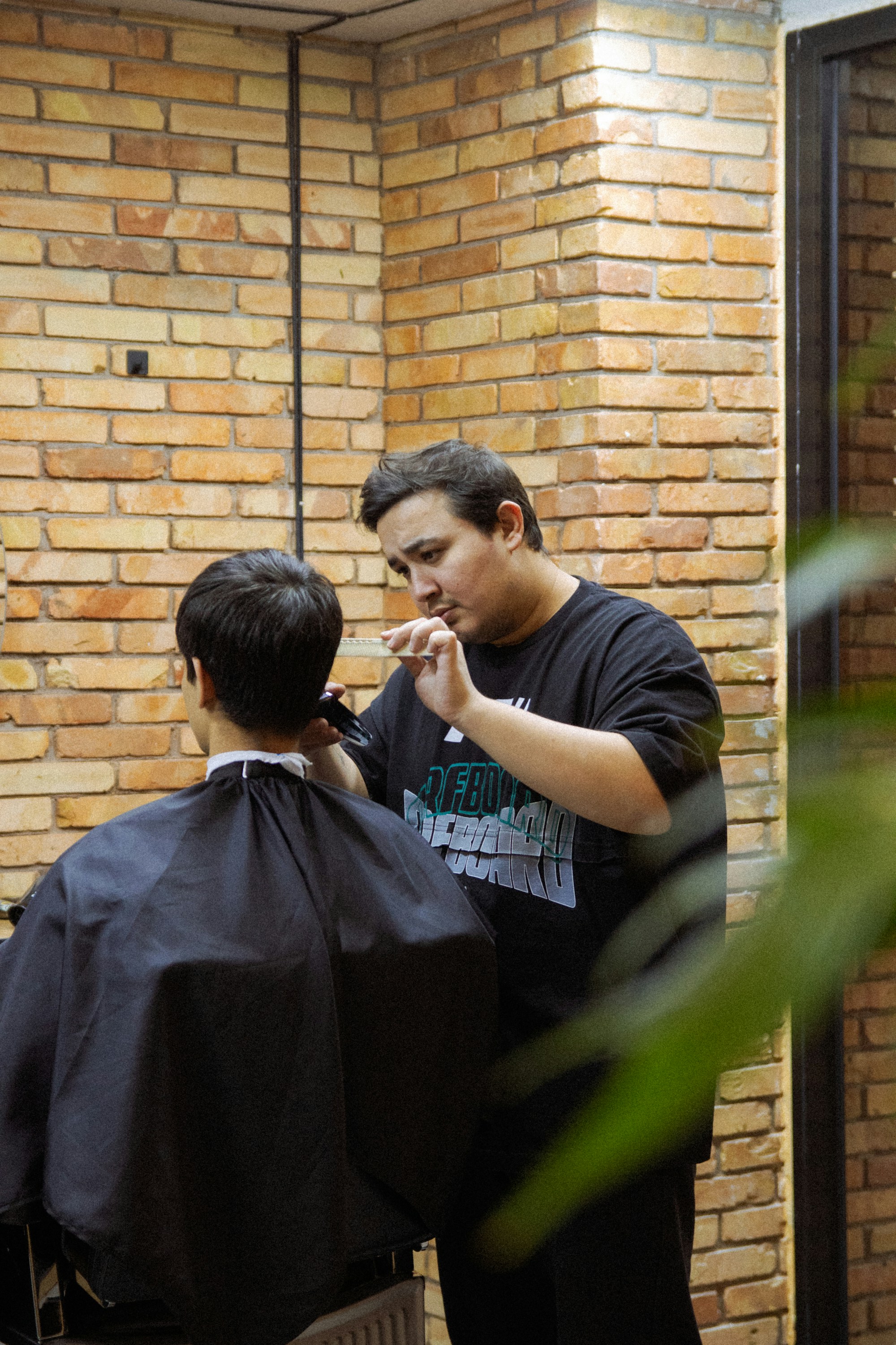 Barber muda merapikan rambut klien dengan detail