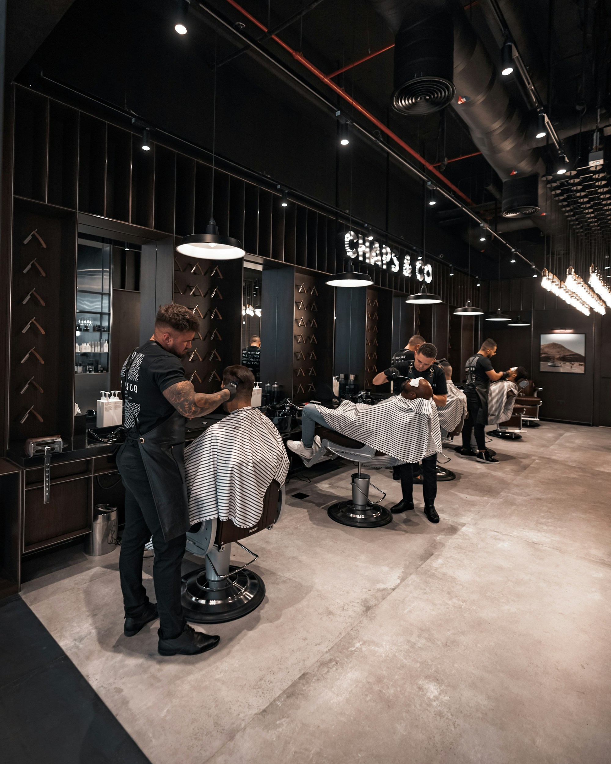Barber merapikan rambut klien di salon modern
