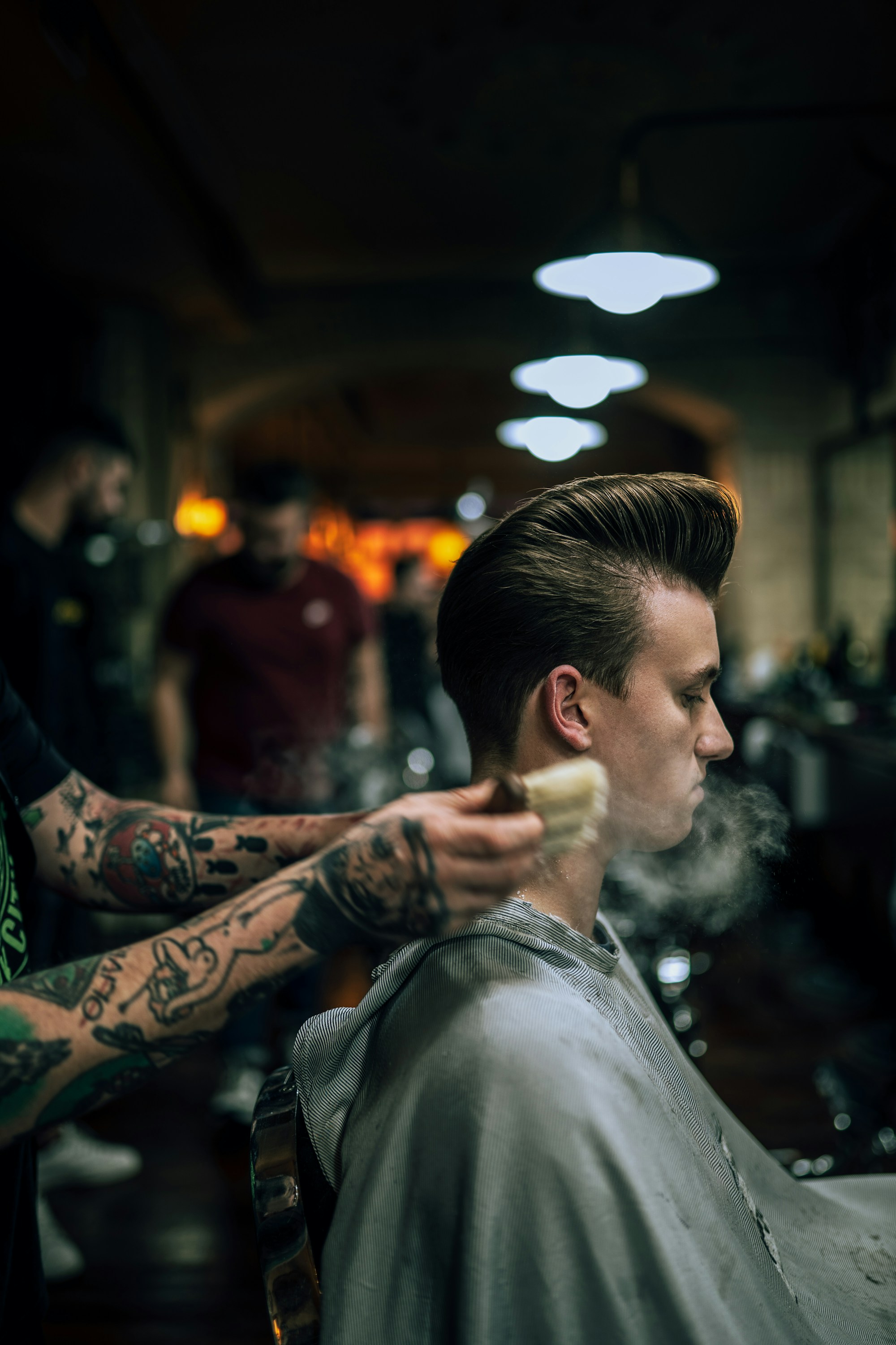 Barber profesional menata rambut pria dewasa muda